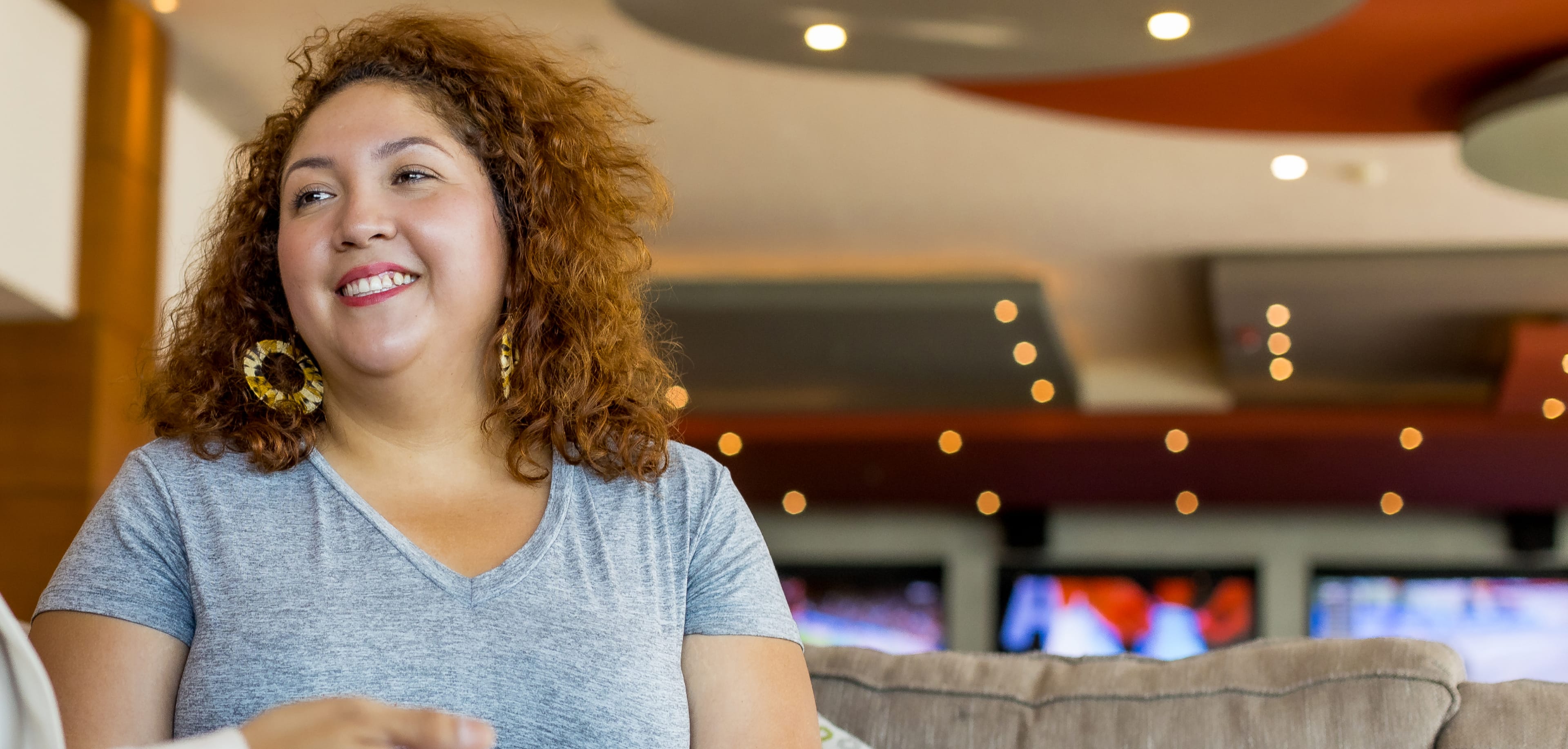 Woman with curly hair sitting on a couch