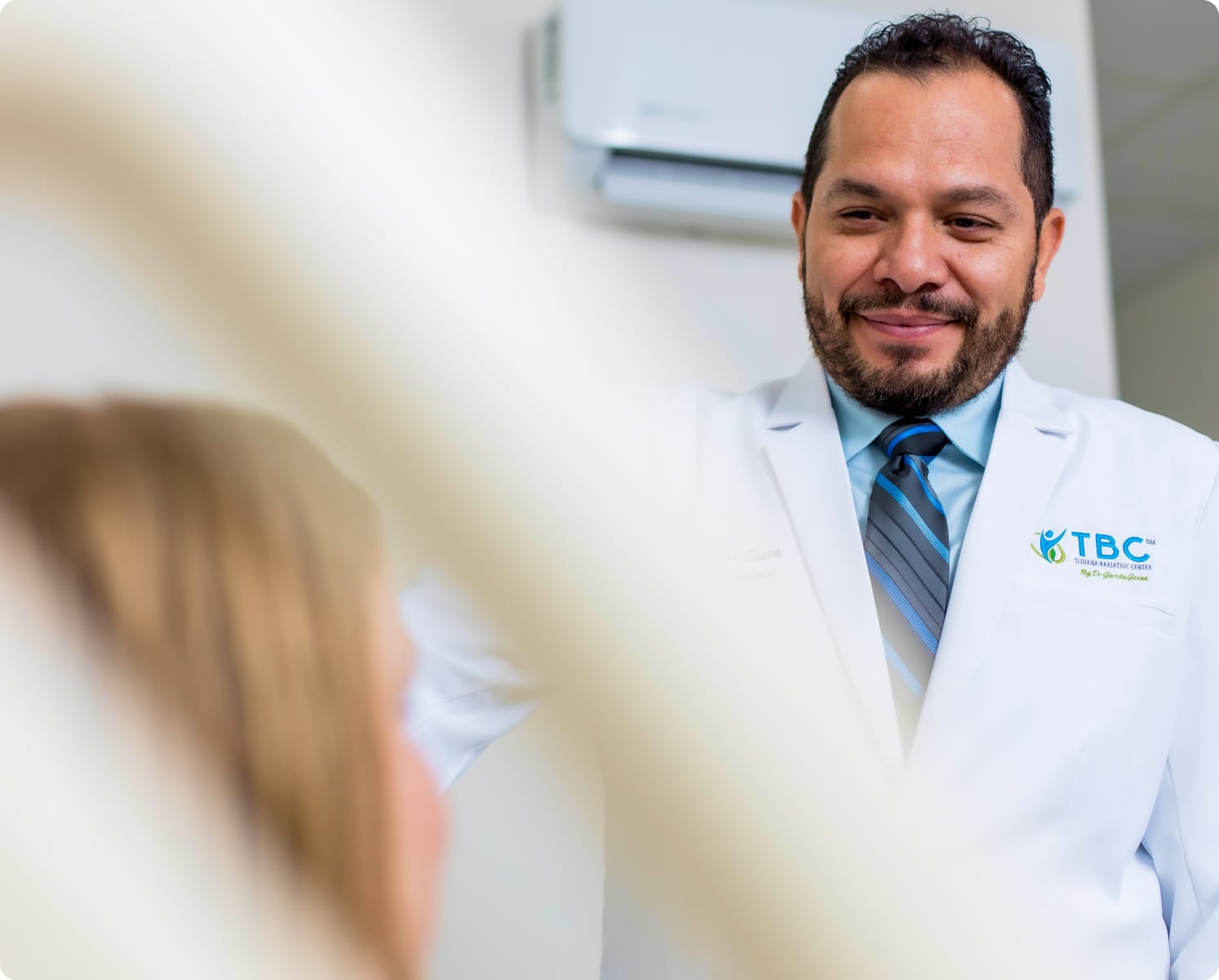 Dr. Fernando Garcia Govea smiling and examining patient