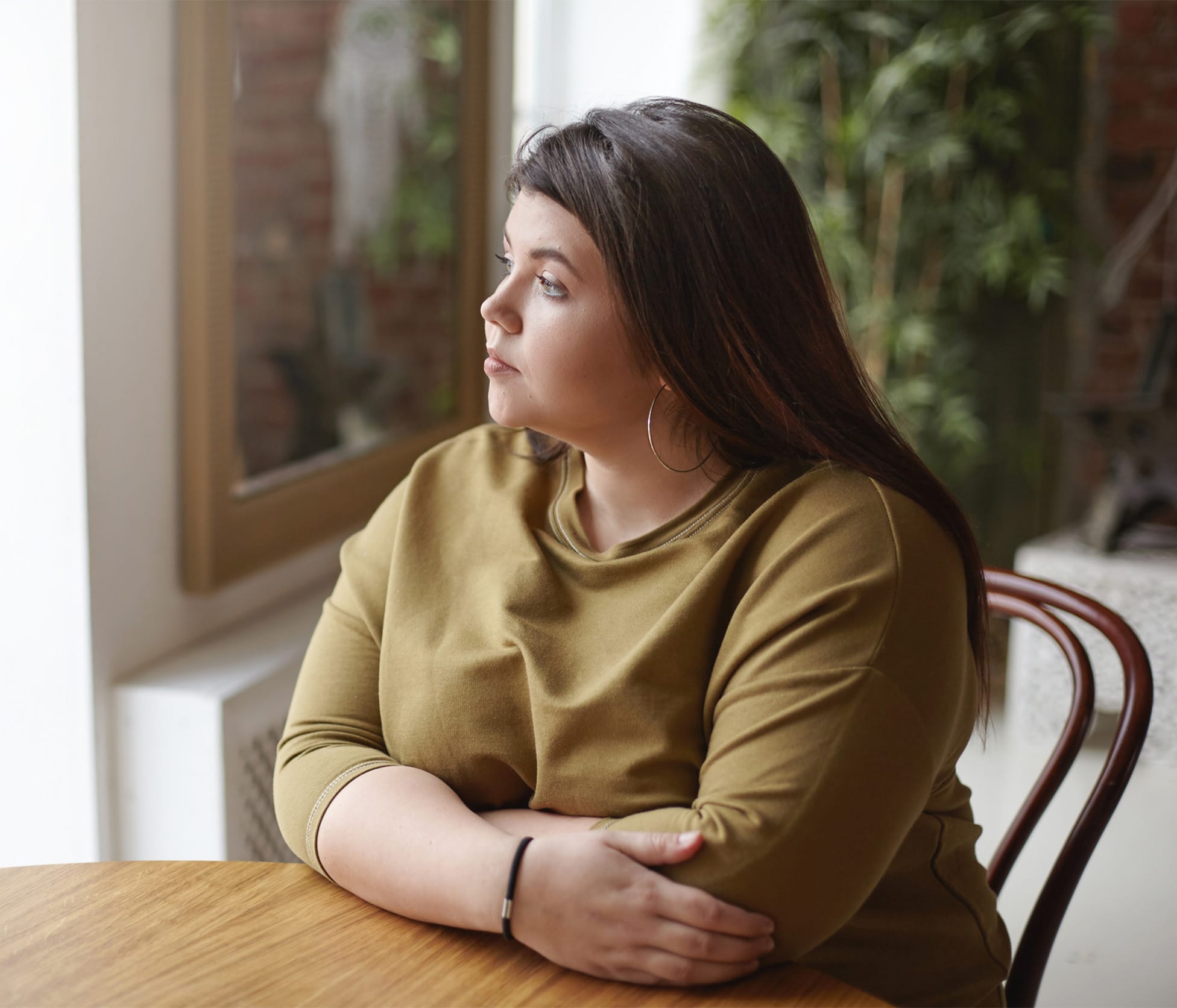 Woman looking outside while sitting at table
