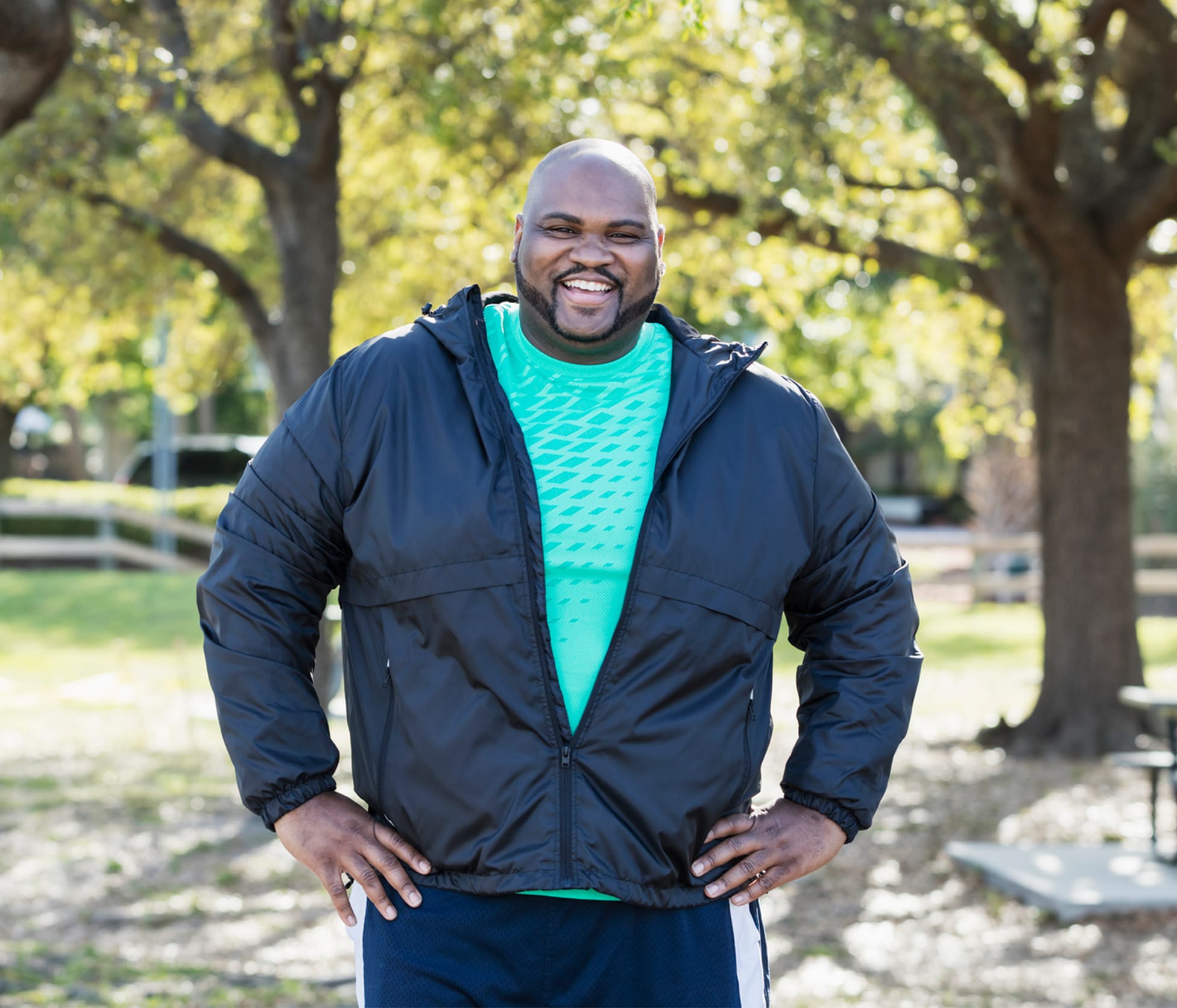 Man Smiling with hands on hips outside